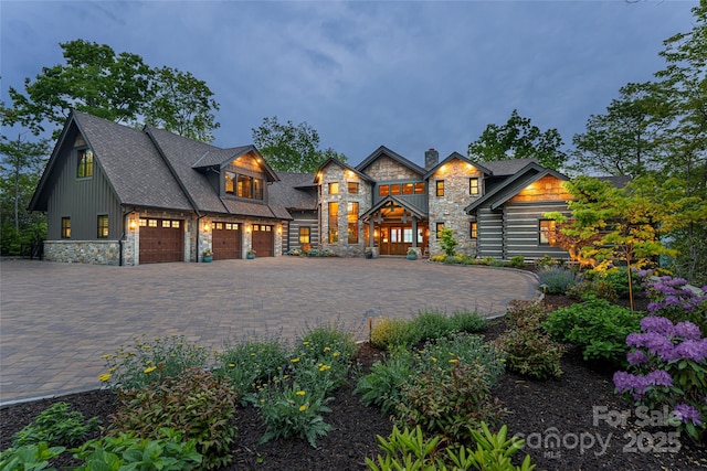 511 Asgi Trl, Maggie Valley, NC 28751 - view of front of property featuring stone siding, an attached garage, a chimney, and decorative driveway