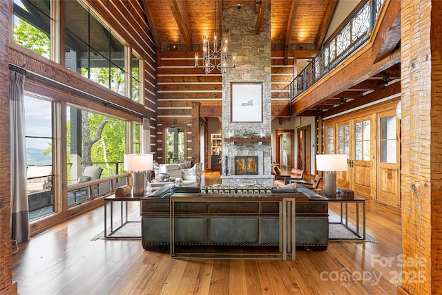 511 Asgi Trl, Maggie Valley, NC 28751 - living room featuring high vaulted ceiling, wood ceiling with exposed beams, hardwood / wood-style floors, and a stone fireplace