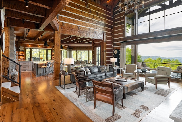 511 Asgi Trl, Maggie Valley, NC 28751 - living room featuring wooden walls, a towering ceiling, wood finished floors, wood ceiling with exposed beams, and stairway