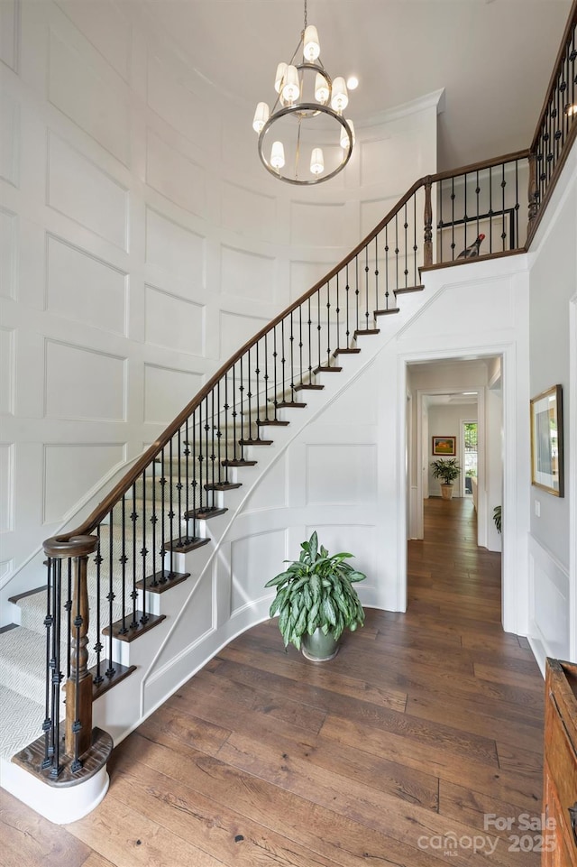 2630 Mary Butler Way, Charlotte, NC 28226 - staircase with a decorative wall, a towering ceiling, a chandelier, and wood finished floors