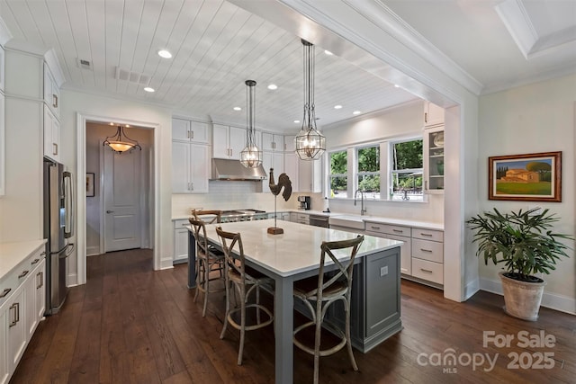 2630 Mary Butler Way, Charlotte, NC 28226 - kitchen featuring under cabinet range hood, a sink, appliances with stainless steel finishes, a breakfast bar, and tasteful backsplash