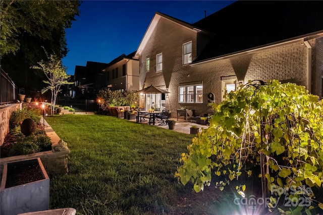 2630 Mary Butler Way, Charlotte, NC 28226 - back of house at night featuring a patio area, brick siding, and a garden