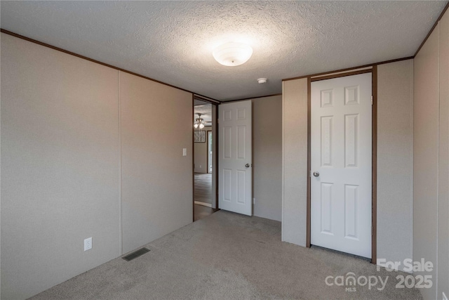 unfurnished bedroom featuring carpet floors and a textured ceiling