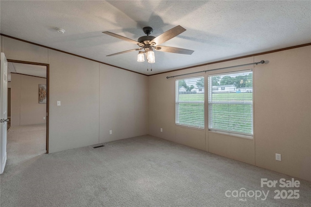 unfurnished room featuring crown molding, carpet flooring, ceiling fan, a smoke detector, and a textured ceiling