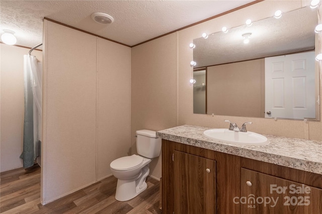 bathroom with wood finished floors, a textured ceiling, vanity, toilet, and a shower with curtain
