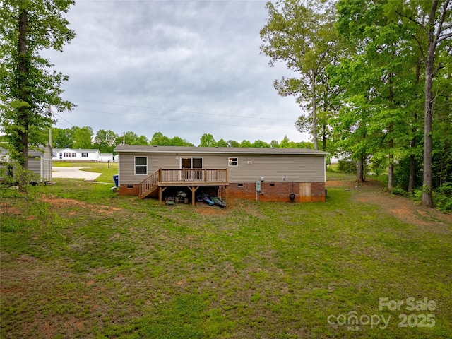 rear view of house featuring crawl space, a wooden deck, a lawn, and stairway