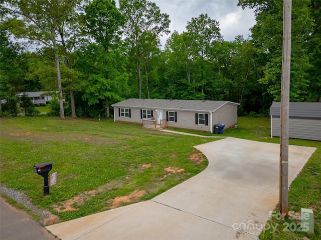 view of front of home with a front lawn, an outbuilding, and a storage unit