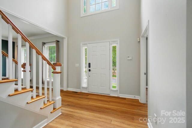 138 Montibello Dr, Mooresville, NC 28117 - foyer with healthy amount of natural light, stairway, a high ceiling, wood finished floors, and baseboards