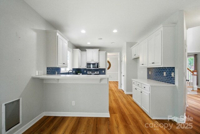 138 Montibello Dr, Mooresville, NC 28117 - kitchen with stainless steel appliances, backsplash, a peninsula, light countertops, and recessed lighting