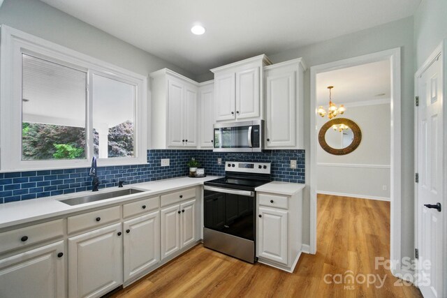 138 Montibello Dr, Mooresville, NC 28117 - kitchen featuring stainless steel appliances, a sink, decorative backsplash, white cabinetry, and light countertops