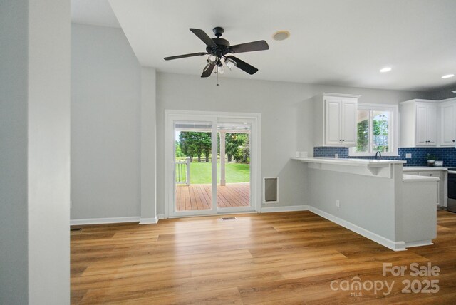 138 Montibello Dr, Mooresville, NC 28117 - kitchen featuring light wood-type flooring, backsplash, white cabinetry, light countertops, and recessed lighting