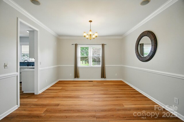 138 Montibello Dr, Mooresville, NC 28117 - spare room featuring a chandelier, a sink, light wood finished floors, ornamental molding, and baseboards
