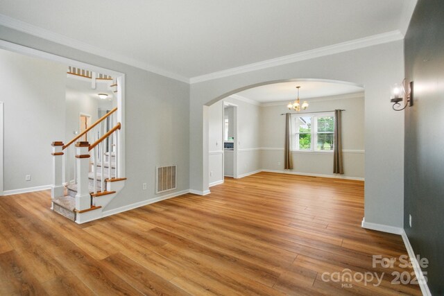 138 Montibello Dr, Mooresville, NC 28117 - unfurnished room featuring wood finished floors, arched walkways, stairway, ornamental molding, and a chandelier