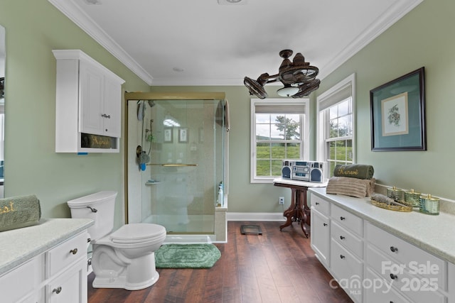 bathroom with ornamental molding, a stall shower, toilet, wood finished floors, and baseboards