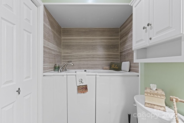 full bathroom featuring toilet, a garden tub, and a sink