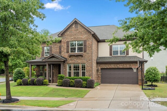 9530 Hightower Oak St, Huntersville, NC 28078 - traditional-style home with concrete driveway, an attached garage, a front yard, and brick siding