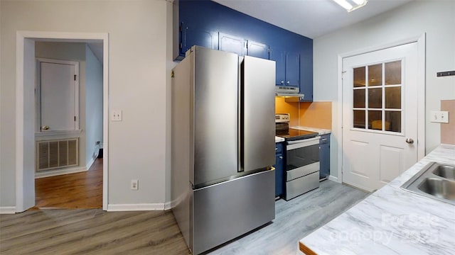 2026 Willow Ridge St, Conover, NC 28613 - kitchen with stainless steel appliances, extractor fan, light wood-type flooring, and blue cabinetry