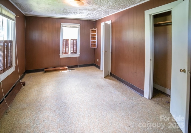 1463 Land St, Lenoir, NC 28645 - unfurnished bedroom with wood walls, baseboards, and a closet