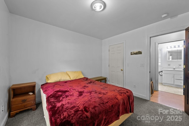 carpeted bedroom with baseboards and connected bathroom