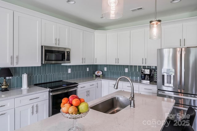 122A Deer Brook Dr Unit A, Shelby, NC 28150 - kitchen with stainless steel appliances, a sink, white cabinetry, hanging light fixtures, and light stone countertops