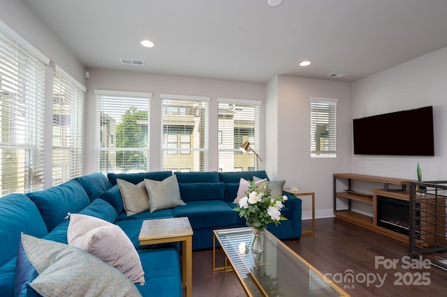 living room with wood finished floors, baseboards, and recessed lighting