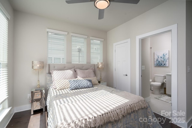 bedroom featuring ensuite bath, baseboards, wood finished floors, and ceiling fan