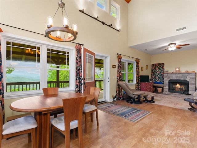 572 Multiflora Way, Waynesville, NC 28785 - dining area featuring plenty of natural light, a chandelier, a fireplace, ceiling fan, and a towering ceiling
