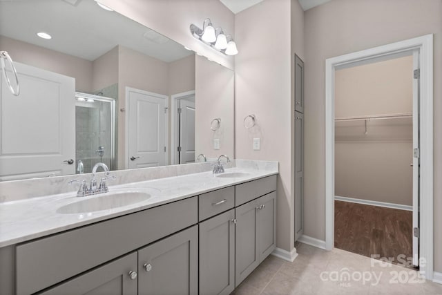4975 Looking Glass Trl, Denver, NC 28037 - bathroom with double vanity, a shower stall, a walk in closet, baseboards, and tile patterned flooring