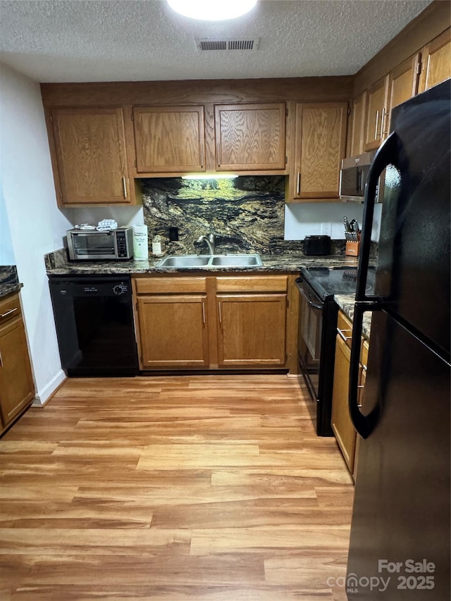 303 Sugar Top Dr Unit 2323, Sugar Mountain, NC 28604 - kitchen featuring black appliances, a sink, light wood-style floors, a textured ceiling, and brown cabinets