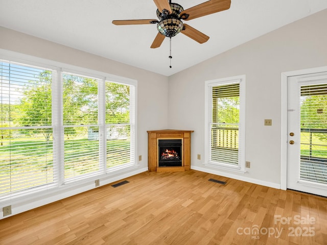 646 Terry Rd, Ellenboro, NC 28040 - unfurnished living room featuring lofted ceiling, light wood finished floors, a lit fireplace, baseboards, and a ceiling fan