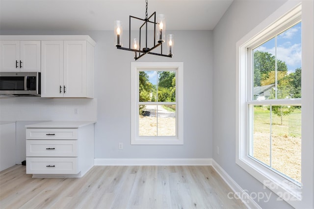 309 Walker St, Kannapolis, NC 28081 - unfurnished dining area with light wood-style flooring, a chandelier, and plenty of natural light