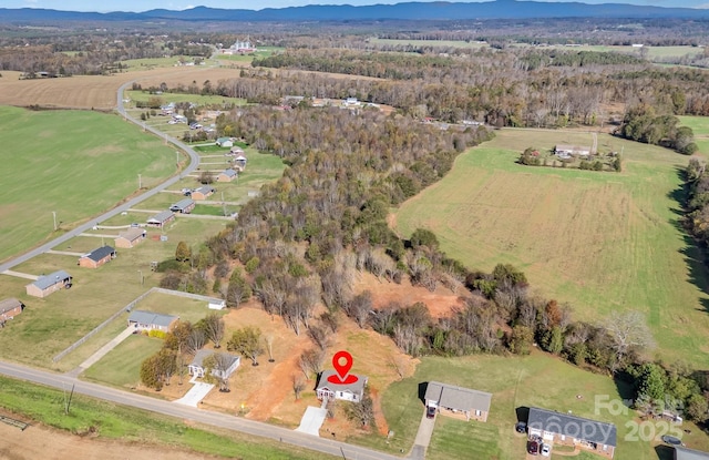 aerial view of property and surrounding area with a mountainous background and rural landscape