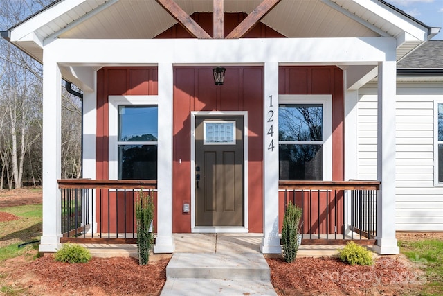 property entrance with roof with shingles and covered porch