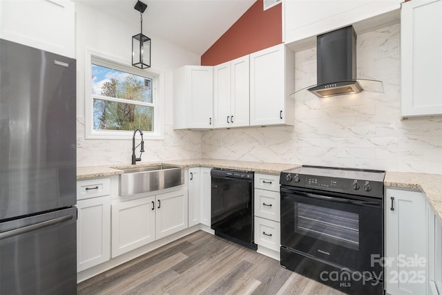 kitchen with black appliances, wall chimney range hood, a sink, vaulted ceiling, and tasteful backsplash