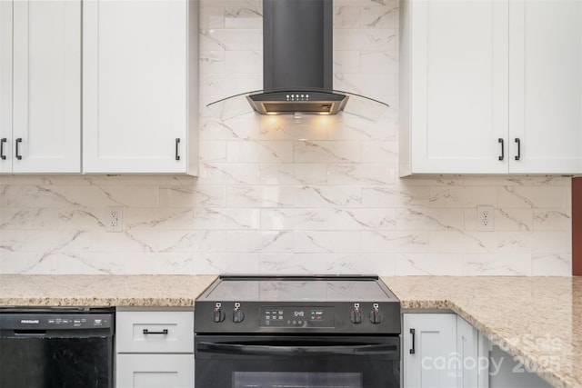 kitchen featuring black appliances, wall chimney exhaust hood, white cabinets, and backsplash