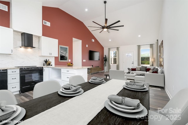 dining room with high vaulted ceiling, light wood-style floors, ceiling fan, and recessed lighting