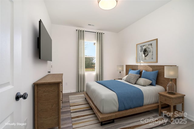 bedroom featuring wood finished floors and baseboards