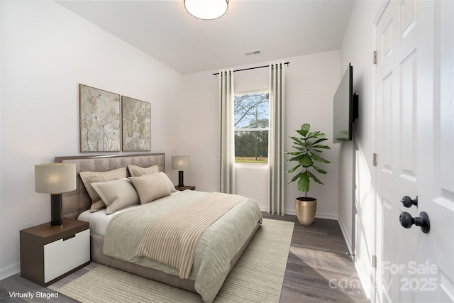bedroom with wood finished floors and baseboards