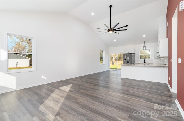 unfurnished living room with high vaulted ceiling, a ceiling fan, dark wood-style flooring, baseboards, and recessed lighting