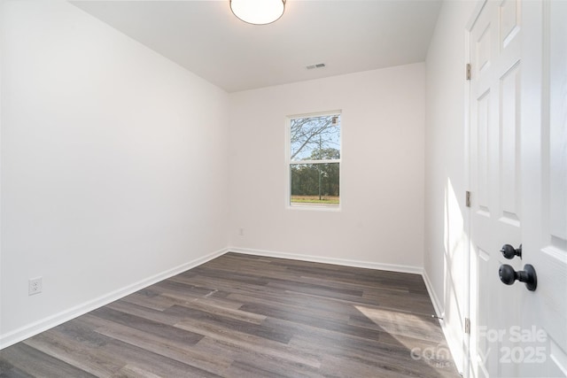 empty room with dark wood-type flooring and baseboards