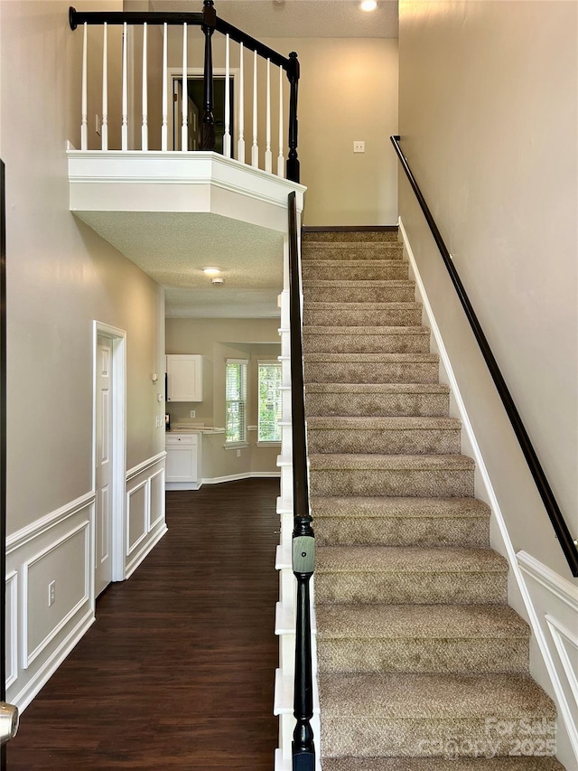 4504 Bellmore Ct, Charlotte, NC 28269 - staircase with wood finished floors and a wainscoted wall