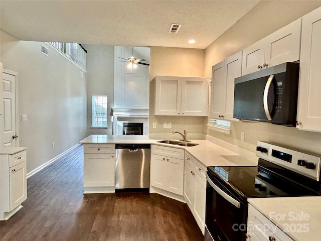 4504 Bellmore Ct, Charlotte, NC 28269 - kitchen featuring stainless steel appliances, a ceiling fan, a peninsula, light countertops, and a textured ceiling