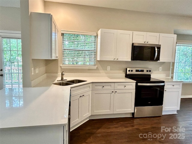 4504 Bellmore Ct, Charlotte, NC 28269 - kitchen featuring appliances with stainless steel finishes, white cabinetry, light countertops, and dark wood finished floors