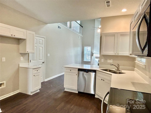 4504 Bellmore Ct, Charlotte, NC 28269 - kitchen with stainless steel dishwasher, stove, dark wood finished floors, ceiling fan, and white cabinets