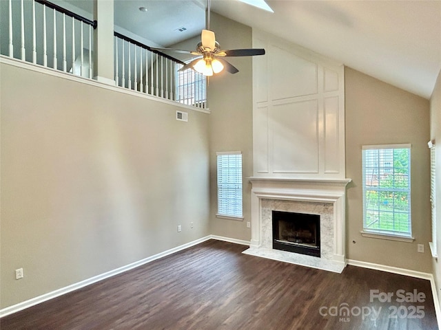 4504 Bellmore Ct, Charlotte, NC 28269 - unfurnished living room featuring high vaulted ceiling, dark wood-style flooring, healthy amount of natural light, ceiling fan, and a premium fireplace