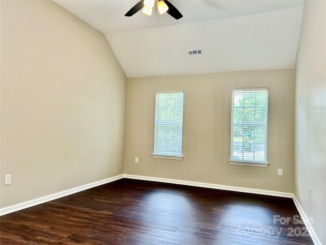 4504 Bellmore Ct, Charlotte, NC 28269 - empty room with healthy amount of natural light, vaulted ceiling, ceiling fan, and dark wood-style floors