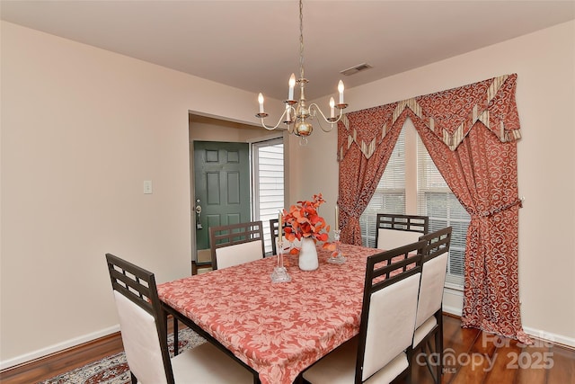 7007 Broad Leaf Ct, Indian Trail, NC 28079 - dining area featuring a chandelier, dark wood-style floors, baseboards, and healthy amount of natural light