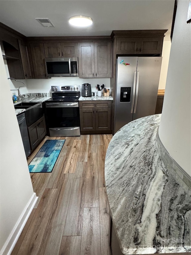 303 Sugar Top Dr Unit 2115, Sugar Mountain, NC 28604 - kitchen with appliances with stainless steel finishes, open shelves, a sink, dark brown cabinetry, and light wood finished floors