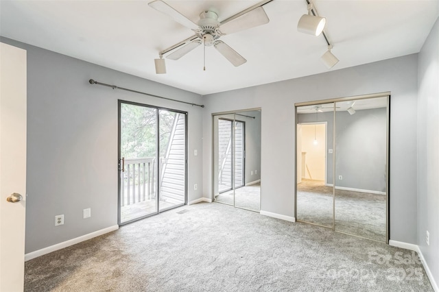 unfurnished bedroom with two closets, access to outside, carpet floors, and baseboards