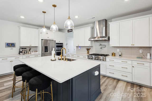 4530 Tournette Dr Unit 18, Indian Land, SC 29707 - kitchen featuring wall chimney exhaust hood, a sink, appliances with stainless steel finishes, tasteful backsplash, and white cabinetry